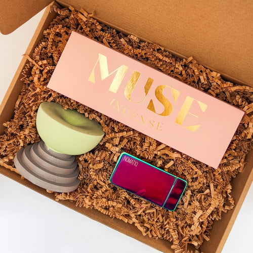 Gift box with an incense holder, box of incense, and an electric lighter on a light background